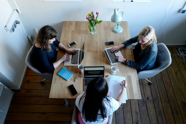 Team working at a table in an office. Source: Unsplash