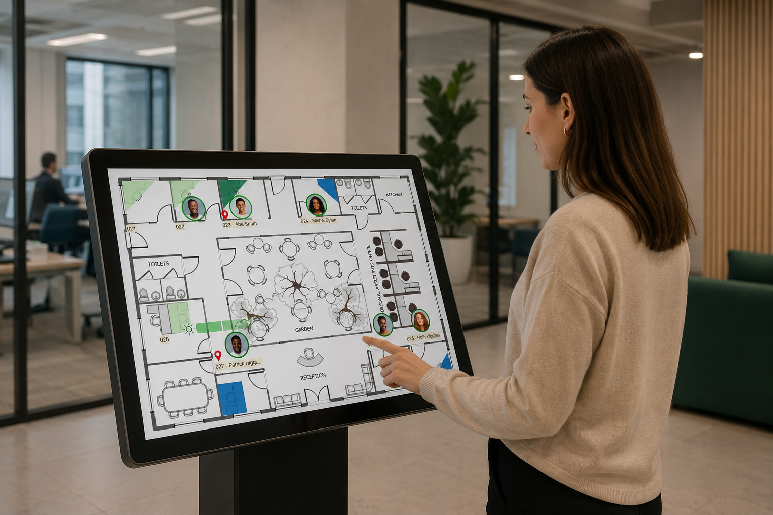 A person using a large interactive Door Tablet wayfinding display showing an office floor plan with occupied and available spaces